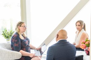 3 people sitting on chairs, talking.